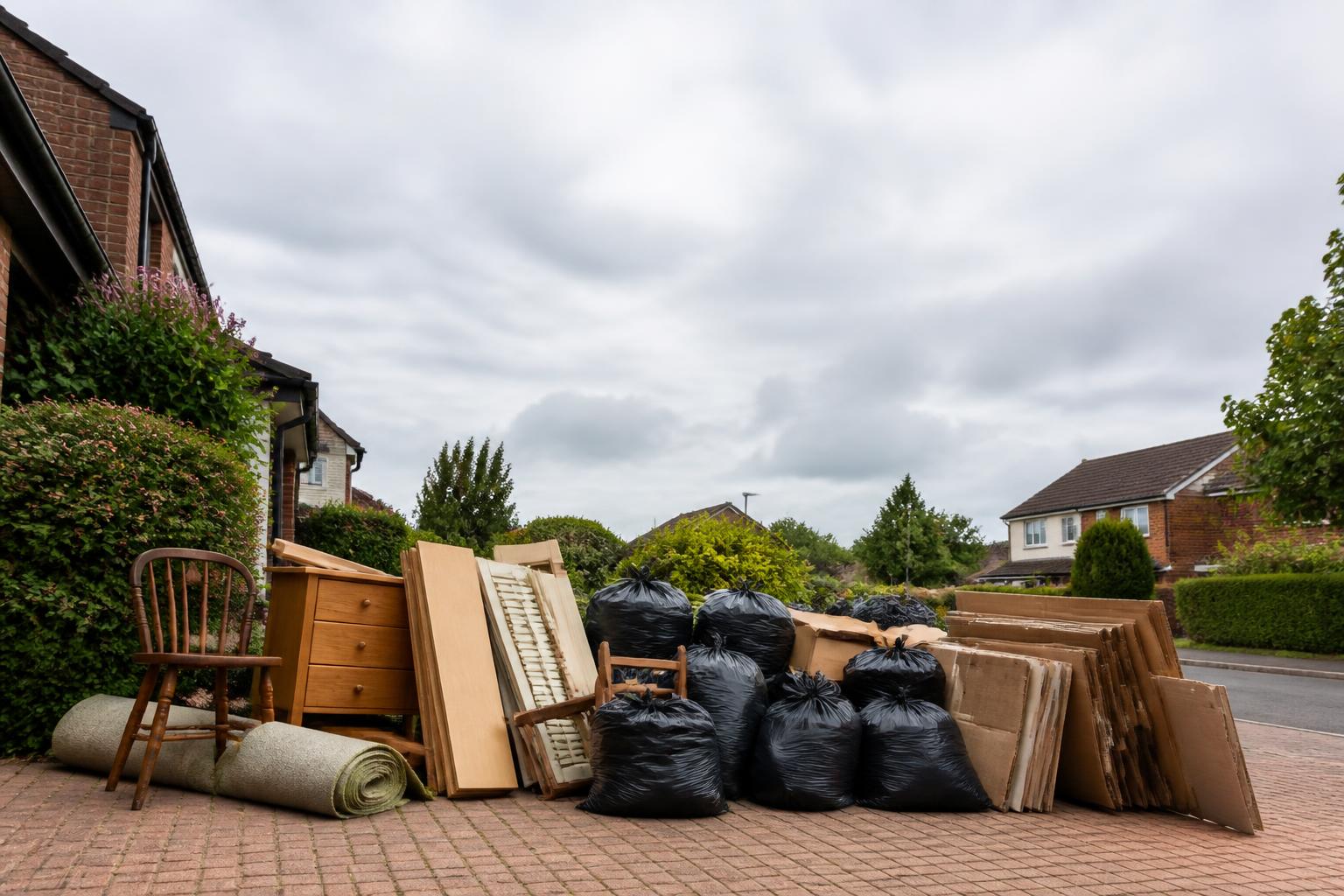 Household waste, furniture and boxes gathered on a driveway ready for clearance